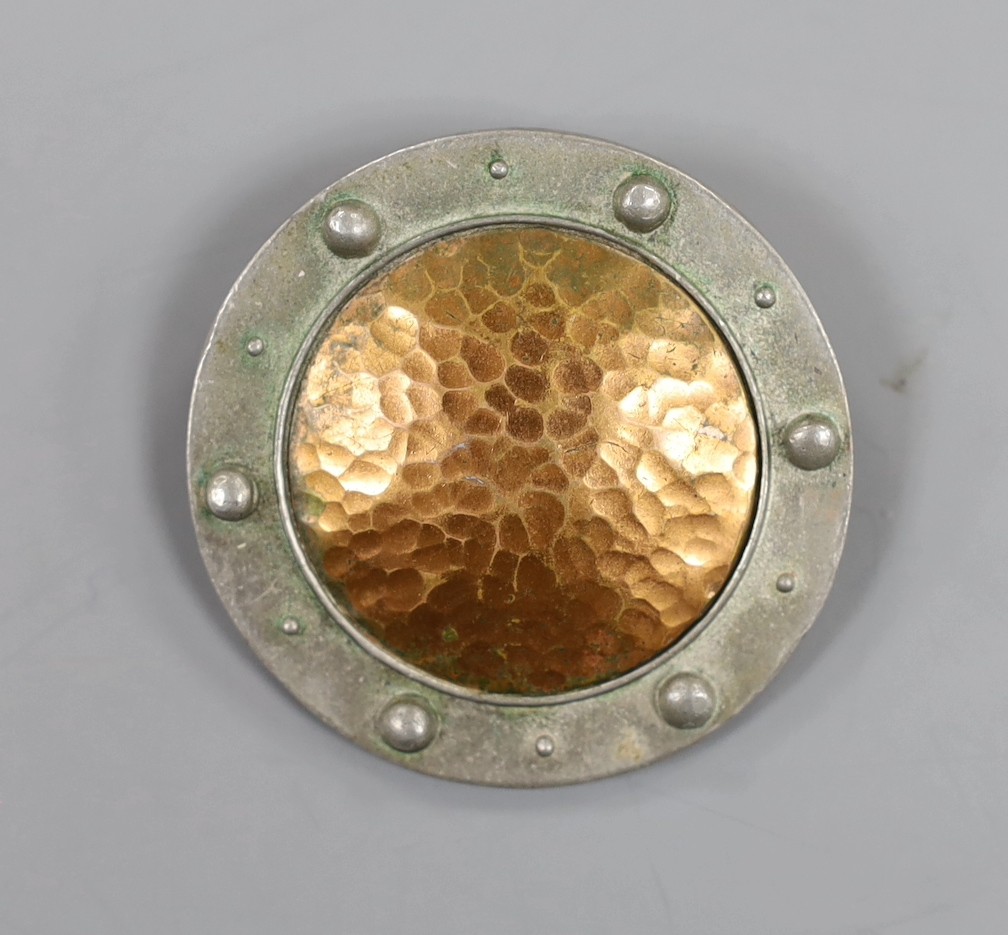 A Liberty pewter and planished copper circular brooch, no. 1024, 47mm.